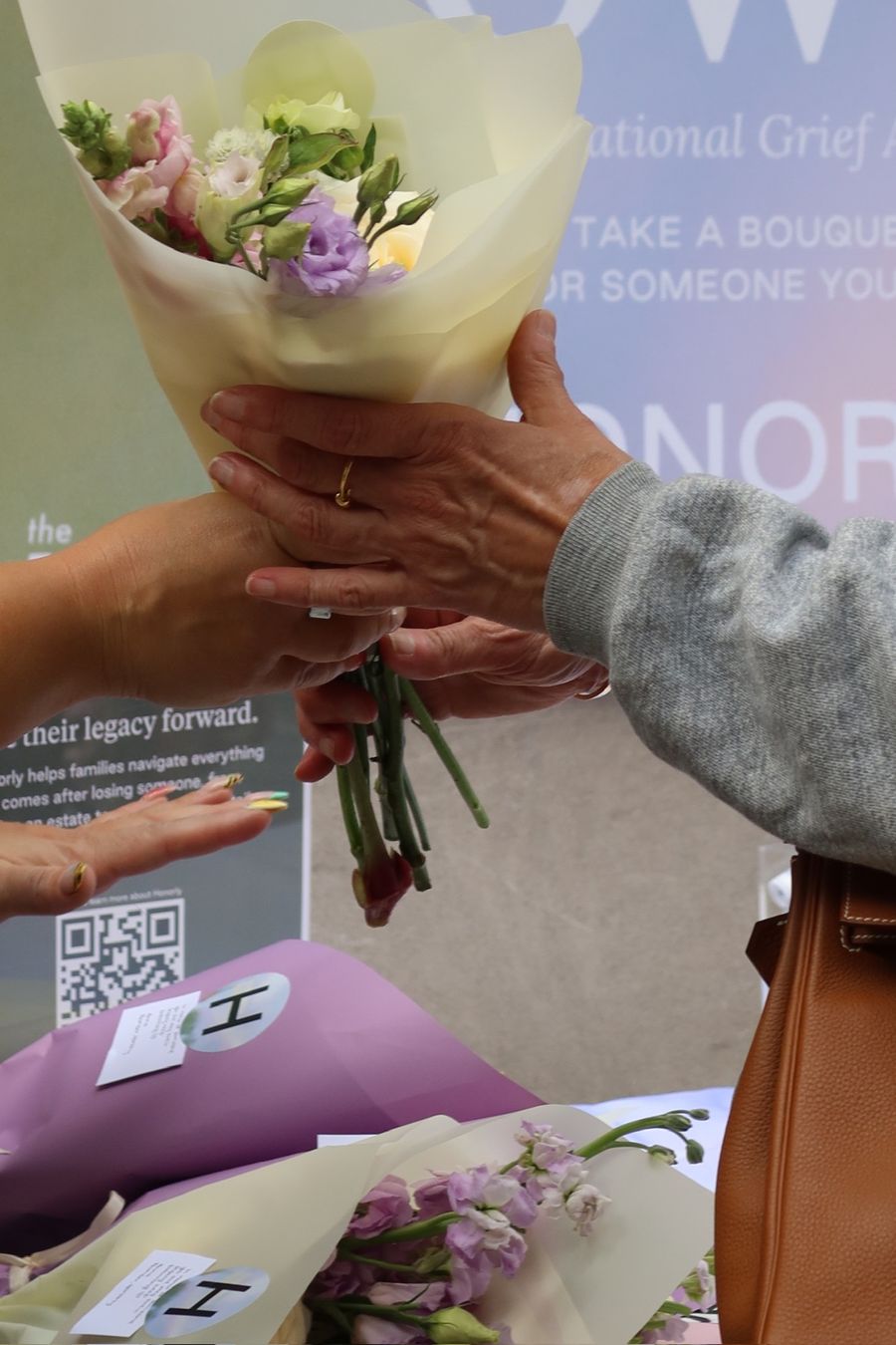 A bouquet passed from one pair of hands to another.